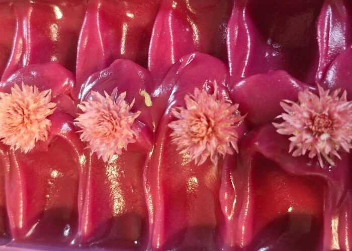 Close up of a glossy pink Fatglow tallow soap with small floral details